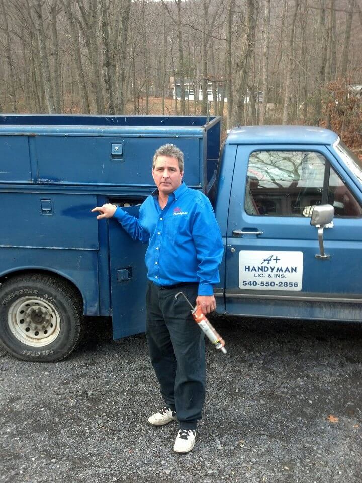 Jim, owner of A+ Handyman, beside the original blue work truck