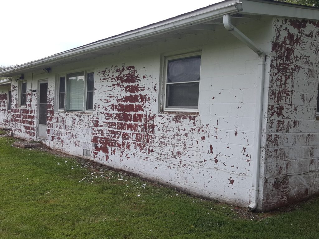 Faded, worn building exterior before repainting in Winchester, VA