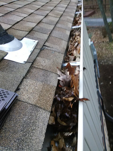Clogged, overflowing gutters before cleaning in Winchester, VA